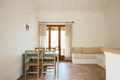 a living room with a table and chairs and a couch at Les Hauts de Santa Giulia in Porto-Vecchio