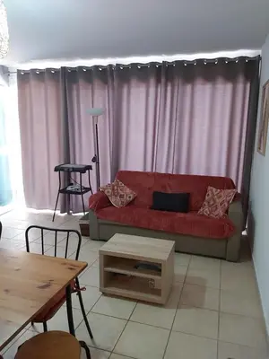 a living room with a red couch and a table at Le Francorsicat in Serra-di-Ferro