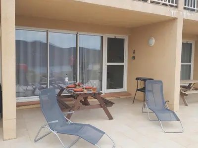 a patio with a wooden table and chairs on a balcony at Le Francorsicat in Serra-di-Ferro