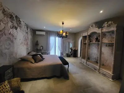 a bedroom with a large bed and a chandelier at VILLA luxueuse privée avec piscine lagon in Calenzana