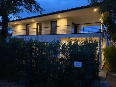 a white house with a balcony at night at LES VILLAS LECCI E MARE in Zonza