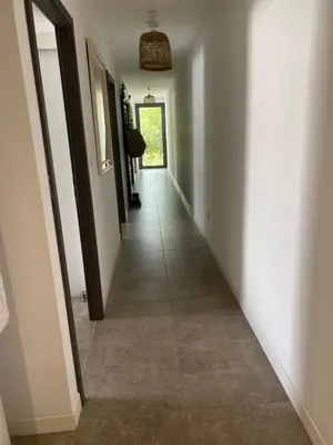 a hallway with white walls and a tile floor at LES VILLAS LECCI E MARE in Zonza