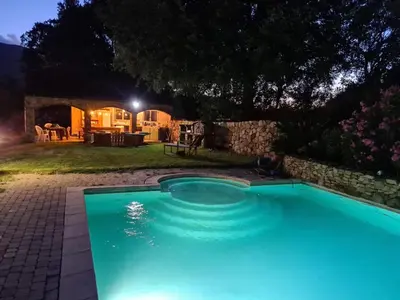 a pool with blue lighting in a yard at night at MAISON DE CARACTERE AVEC PISCINE in Sartène