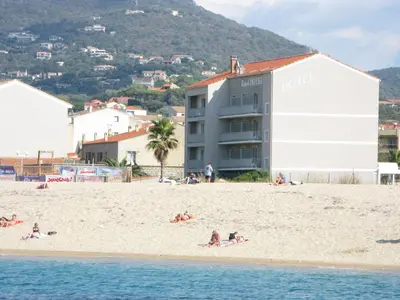 a group of people on a beach near the water at Hôtel Beach in Propriano