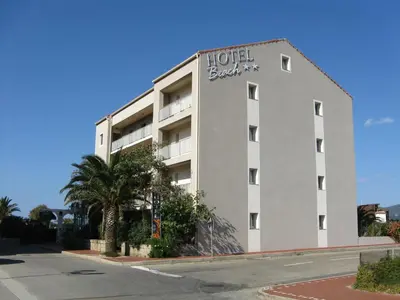 a hotel building with a hotel board sign on it at Hôtel Beach in Propriano