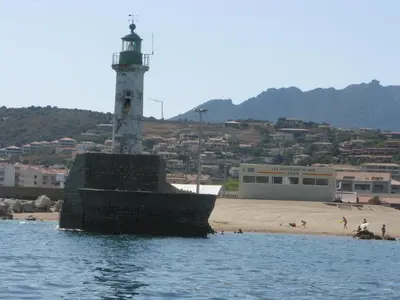 a lighthouse on the shore of a beach at Hôtel Beach in Propriano