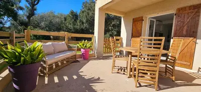 a patio with a couch and a table and chairs at T2 Paisible Quartier Vigna Majo, Olmeto in Olmeto
