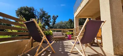 two folding chairs sitting on a porch on a house at T2 Paisible Quartier Vigna Majo, Olmeto in Olmeto