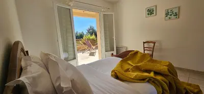 a bedroom with a bed with a yellow blanket on it at T2 Paisible Quartier Vigna Majo, Olmeto in Olmeto