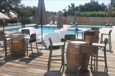 a group of tables and chairs and a pool at Casa Ghjulia St-Cyprien Rétro Chic in Lecci