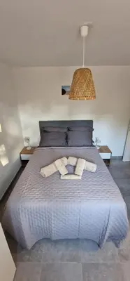 a bedroom with a bed with two towels on it at Casa Ghjulia St-Cyprien Rétro Chic in Lecci