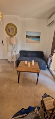 a living room with a blue couch and a table at Casa Ghjulia St-Cyprien Rétro Chic in Lecci