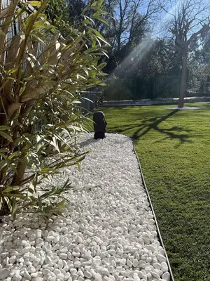 a panda sitting on a rock path in a garden at Appartement jardin à deux pas de la mer Classé 3 étoiles in Poggio-Mezzana