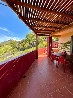 a patio with a wooden pergola and a table and chairs at Domaine Victoria in SantʼAntonino