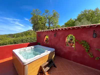 a hot tub on the back of a house at Domaine Victoria in SantʼAntonino