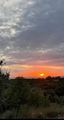 a sunset with the sun setting in the sky at Maison Murato in San-Giuliano