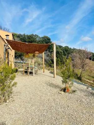 a patio with a hammock and a house at Maison Murato in San-Giuliano