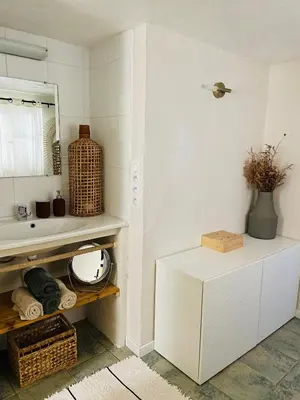 a white bathroom with a sink and a mirror at Maison Murato in San-Giuliano