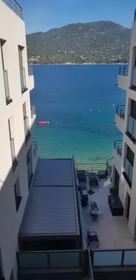 a view of the ocean from between two buildings at MAGNIFIQUE APPARTEMENT LES PIEDS DANS L'EAU PROPRIANO in Propriano