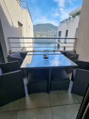 a table on the balcony of a building at MAGNIFIQUE APPARTEMENT LES PIEDS DANS L'EAU PROPRIANO in Propriano