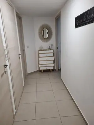a hallway with a tiled floor and a mirror at MAGNIFIQUE APPARTEMENT LES PIEDS DANS L'EAU PROPRIANO in Propriano
