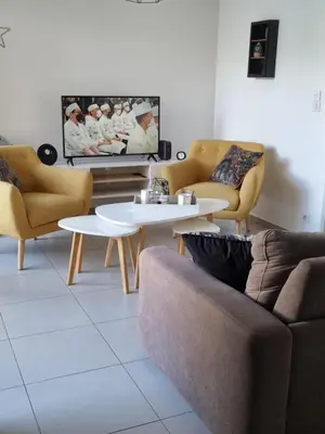 a living room with a couch and tables and a tv at MAGNIFIQUE APPARTEMENT LES PIEDS DANS L'EAU PROPRIANO in Propriano