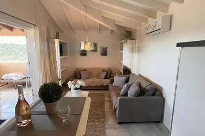 a living room with a couch and a table at Appartement 4 pers vue sur la baie de Santa Giulia in Porto-Vecchio