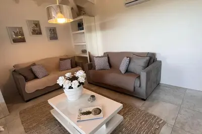 a living room with two couches and a coffee table at Appartement 4 pers vue sur la baie de Santa Giulia in Porto-Vecchio