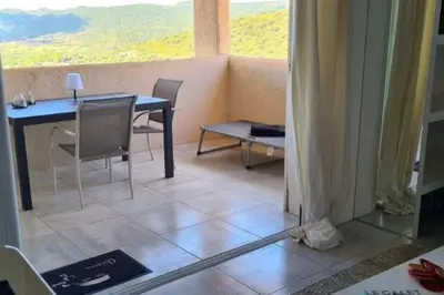 a dining room with a table and chairs and a window at Appartement 4 pers vue sur la baie de Santa Giulia in Porto-Vecchio