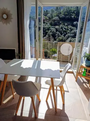 a white table and chairs in a room with a window at JOLI 2 PIECES SERRIERA in Serriera
