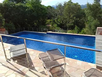 two chairs sitting next to a swimming pool at Villa classée 5* 7 chambres piscine spa plage à 5' in Sainte-Lucie de Porto-Vecchio