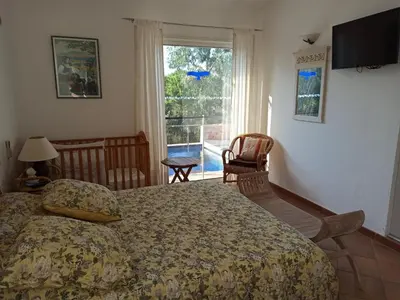 a bedroom with a bed and a large window at Villa classée 5* 7 chambres piscine spa plage à 5' in Sainte-Lucie de Porto-Vecchio