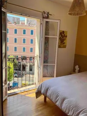 a bedroom with a bed and a large window at F3 de charme centre ville Ajaccio in Ajaccio
