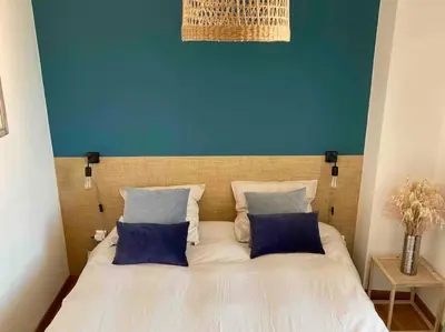 a bedroom with a bed with a blue wall at F3 de charme centre ville Ajaccio in Ajaccio