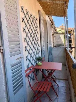 a red table and two chairs on a balcony at F3 de charme centre ville Ajaccio in Ajaccio