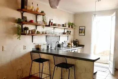 a kitchen with a counter with two chairs and a sink at F3 de charme centre ville Ajaccio in Ajaccio