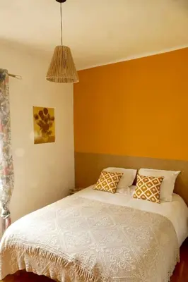 a bedroom with a bed with a yellow wall at F3 de charme centre ville Ajaccio in Ajaccio