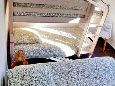 a bunk bed with a ladder next to a bed at Résidence Confort avec Piscine - Proche des plages in Bonifacio