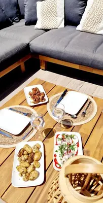 a table with plates of food and wine glasses at Résidence Confort avec Piscine - Proche des plages in Bonifacio