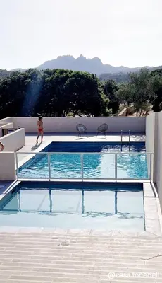 a person standing next to a swimming pool at Résidence Confort avec Piscine - Proche des plages in Bonifacio