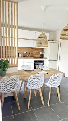 a kitchen with a wooden table and chairs at Résidence Confort avec Piscine - Proche des plages in Bonifacio