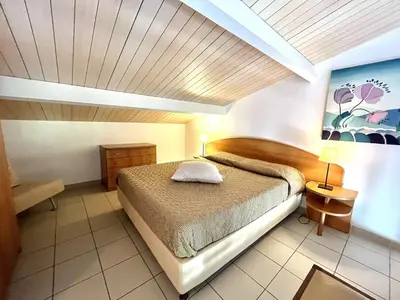 a bedroom with a bed and a wooden ceiling at Appartement Bella Vista 302 Porticcio in Porticcio