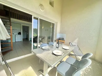 a dining table and chairs in a living room at Appartement Bella Vista 302 Porticcio in Porticcio
