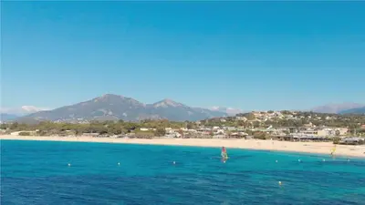 a beach with a sail boat in the water at Appartement Bella Vista 302 Porticcio in Porticcio