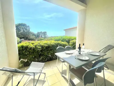 a white table and chairs on a balcony with a view at Appartement Bella Vista 302 Porticcio in Porticcio