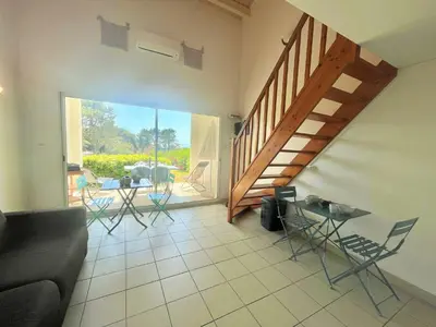a living room with a staircase and a table and chairs at Appartement Bella Vista 302 Porticcio in Porticcio