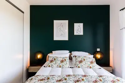 a bedroom with a large bed with a green wall at Joséphine - Appt vue exceptionnelle Porto-Vecchio in Porto-Vecchio