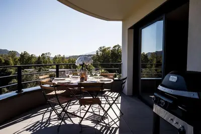 a table and chairs on a balcony with a view at Joséphine - Appt vue exceptionnelle Porto-Vecchio in Porto-Vecchio