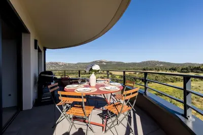 a table and chairs on a balcony with a view at Joséphine - Appt vue exceptionnelle Porto-Vecchio in Porto-Vecchio