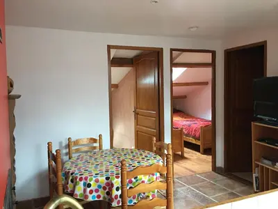 a bedroom with a bed and a table and a mirror at Appartement sous les toits in Piana